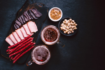 beer and snacks. bar table. restaurant, pub, food concept. delicious lager drink and meat appetizers set- ham, sausages and jerky. friday party atmosphere, craft brewery background
