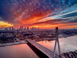 Fototapeta na wymiar Beautiful panoramic aerial drone sunset view to Warsaw city center with skyscrapers and Swietokrzyski Bridge (En: Holy Cross Bridge) - is a cable-stayed bridge over the Vistula river in Warsaw, Poland
