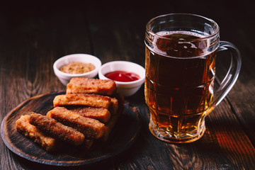 lager beer and snacks. bar table. restaurant, pub, food concept. delicious drink and breaded cheese sticks with sauces set. friday party atmosphere, craft brewery background