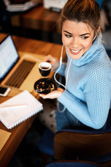 Happy casual businesswoman day dreaming on coffee break in a cafe.