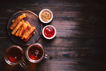 lager beer and snacks. bar table. restaurant, pub, food concept. delicious drink and breaded cheese sticks with sauces set. friday party atmosphere, craft brewery background