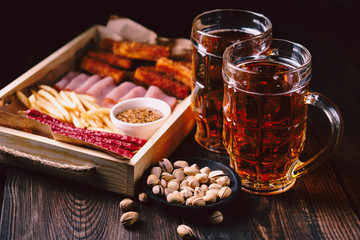 beer and snacks. bar table. restaurant, pub, oktoberfest food. delicious lager drink and appetizers set- fried cheese, ham, sausages and jerky. friday party atmosphere, craft brewery concept