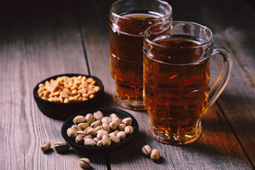 bar table. two mugs of lager beer and snacks set. restaurant, pub, food concept. delicious drink and salty nuts. oktoberfest atmosphere, craft brewery background