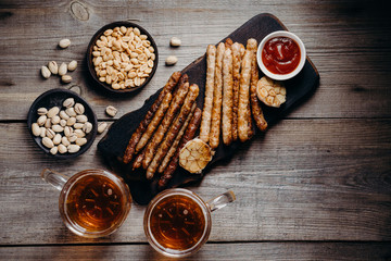 beer and snacks. friday party atmosphere, craft brewery, bar table. restaurant, pub, food concept. delicious lager drink, grilled sausages, garlic and sauce
