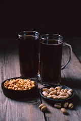 bar table. dark beer and snacks set. restaurant, pub, food concept. delicious drink and salty nuts. oktoberfest atmosphere, craft brewery background