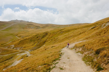 Mountain biker girl riding down the bike trail in Livigno Italy