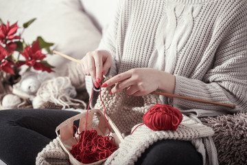 Obraz na płótnie Canvas woman knits knitting needles on the couch