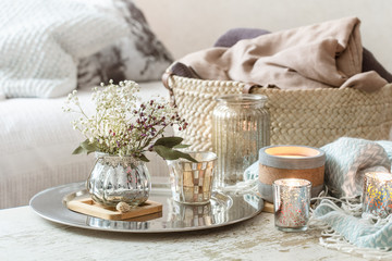 Home decorations in the interior. A turquoise blanket and wicker basket with a vase of flowers and...