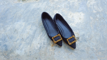 a female shoe on the cement wall