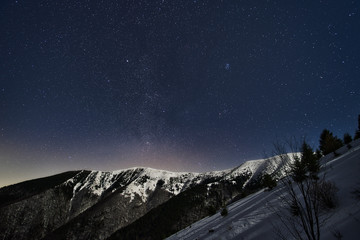 Winter snow covered crest of Mala Fatra mountains Slovakia and starry night sky above
