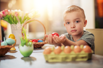 Little boy coloring eggs for Easter holiday