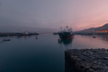 Obraz premium Seaport from Hondarribia at golden hour with fullmoon, at the Basque Country.