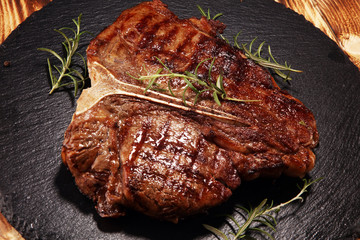 Grilled T-bone steak on stone cutting board.