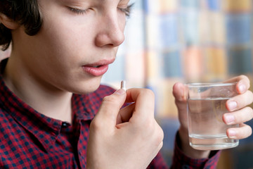 teenager take pill at home b