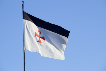 Templar flag weaving over blue sky