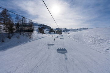 Aussicht von Waidring Steinplatte auf Winterlandschaft mit Schipiste und Schifahrer