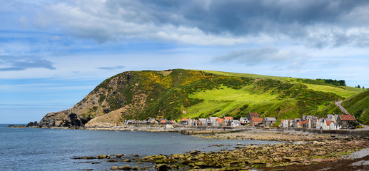 Panorama of single row of houses now holiday lets of Crovie coastal fishing village on Gamrie Bay North Sea Aberdeenshire Scotland UK