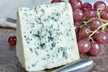 Blue Auvergne semi-hard AOP French blue cheese made from raw cow milk in Auvergne, France served as dessert with grapes
