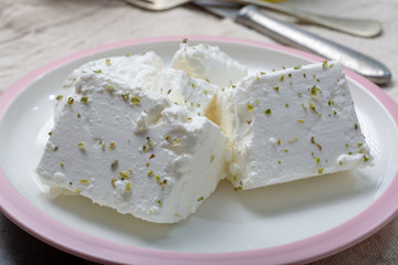 Fresh young soft white Feta cheese on plate seasoned with dried oregano herb