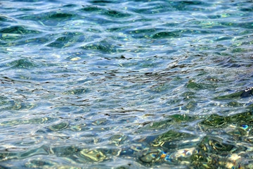 Sunlight reflects on a sea surface. Beautiful clear water. Selective focus.