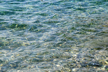 Sunlight reflects on a sea surface. Beautiful clear water. Selective focus.