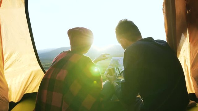 Young man and woman exploring map in the mountain.