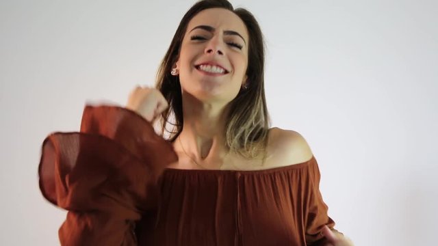 Young beautiful caucasian girl happily rejoicing saying yes on white background
