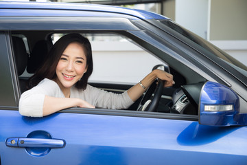 Asian women driving a car and smile happily with glad positive expression during the drive to...