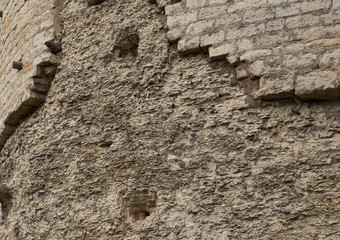 Stone wall texture. Weathered surface of the ancient fortress tower. Uneven rough cracked stonework. Perfect for background and design.