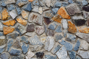 Stone wall texture. Uneven rough surface of granite masonry. Perfect for background and design.