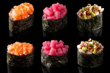 Gunkan set of fresh salmon, tuna and smoked eel with avocado on black background. Traditional Japanese cuisine