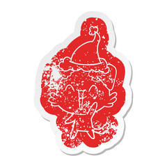 happy little dog cartoon distressed sticker of a wearing santa hat