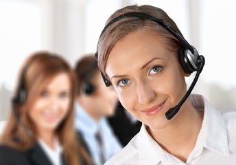 Female call center employee with coworkers on background
