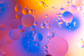 oily drops  in water with colorful background, close-up 