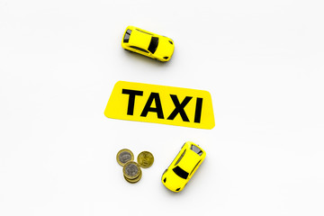 Taxi operator concept. Chip service. Price of services. Sign taxi ner car toy and coins on white background top view copy space
