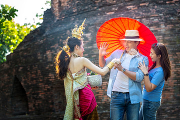 Tourists are enjoying the Songkran Festival. Thai girls and Young caucasian man splashing water during festival Songkran. Celebrated in a traditional New Year of Phra Nakhon Si Ayutthaya, Thailand.