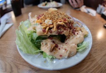 salad is piled with unhealthy ingredients