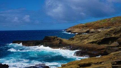 Fototapeta na wymiar Blue ocean waves hit Hawaii rock coast 