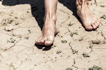 Girl's bare feet on dry ground