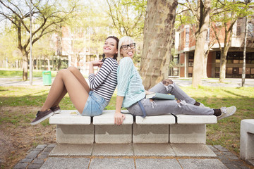 Young students sitting outdoors and smiling