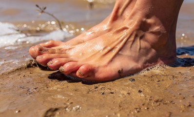 Fototapeta na wymiar Feet of a man by the sea