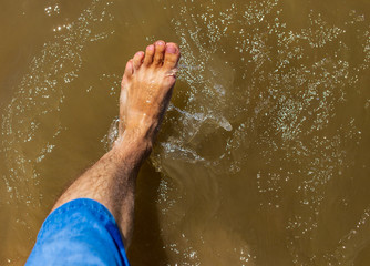 Fototapeta na wymiar Feet of a man by the sea