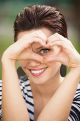 Beautiful young woman sitting on a bench outdoors and looking in to a objective