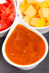 Fototapeta na wymiar Homemade pumpkin sauce or ketchup with ingredients in bowls