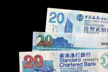 Three different bills in twenty Hong Kong dollars on a dark background close up