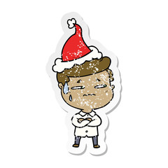 distressed sticker cartoon of a anxious man wearing santa hat
