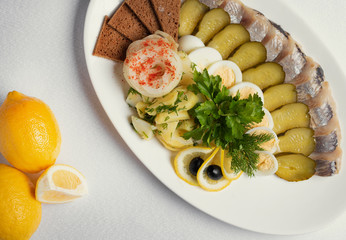 fish and vegetable cuts for beer, olives, pickled cucumbers,boiled eggs and lemon with micro greens on plate