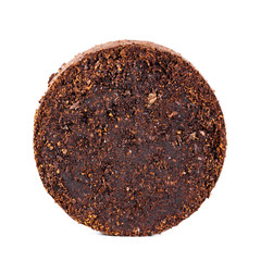 Rund gepresster Kaffeesatz isoliert vor weißem Hintergrund