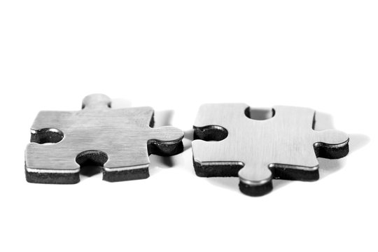 Zwei Puzzleteile werden zusammengef&uuml;gt, freigestellt vor wei&szlig;em Hintergrund