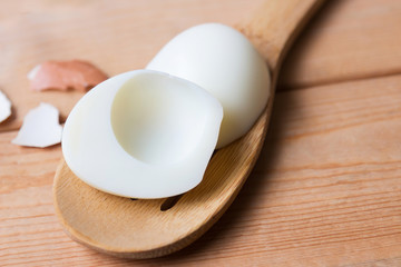 Fototapeta na wymiar Peeling boiled egg on wooden spoon 